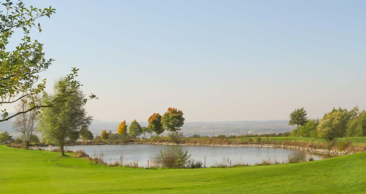 Golfplatz im bayerischen Voralpenland mit Bergkulisse.