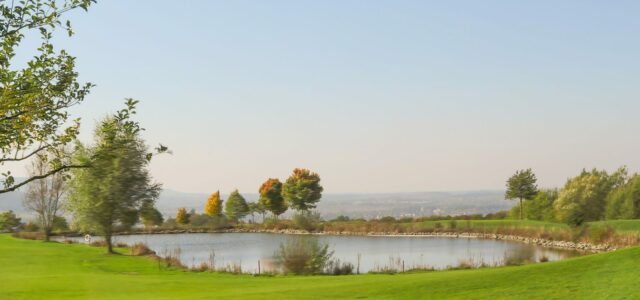 Golfplatz im bayerischen Voralpenland mit Bergkulisse.