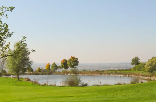 Golfplatz im bayerischen Voralpenland mit Bergkulisse.