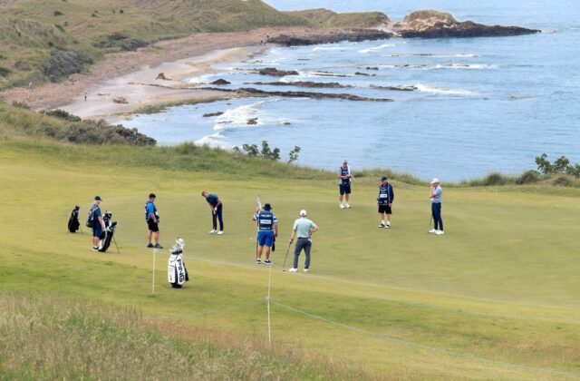 Green en bord de mer, joueurs et sacs rassemblés autour du drapeau.