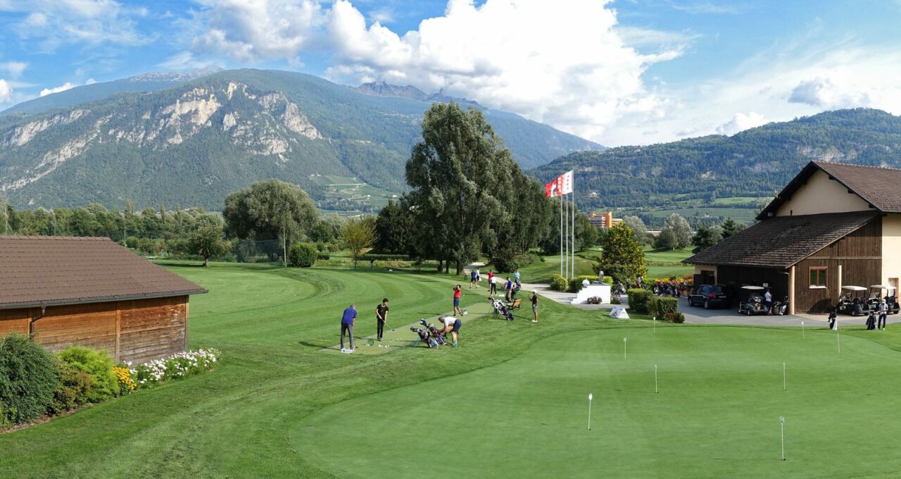 Practice et putting green du Golf Club de Sion devant les montagnes valaisannes.