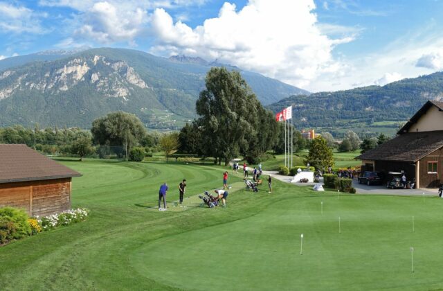 Practice et putting green du Golf Club de Sion devant les montagnes valaisannes.