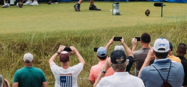 Des spectateurs filment un joueur au départ, derrière la corde.