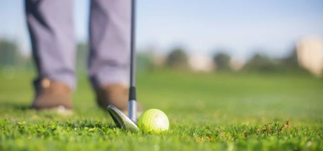 Semelle d'un club posée derrière la balle sur le gazon