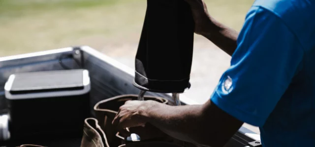 Golfer opening a cool box beside the course