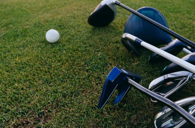 Set of irons and a driver lying on the grass