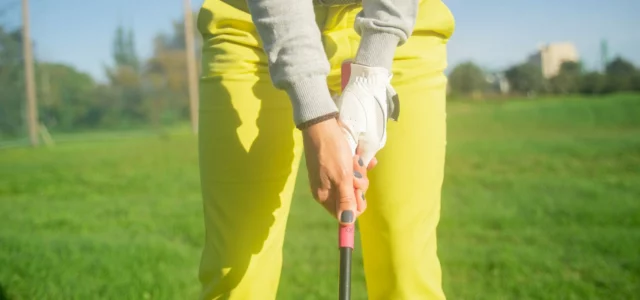 Mains d'un golfeur en prise sur le grip