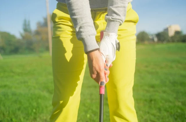 Mains d'un golfeur en prise sur le grip