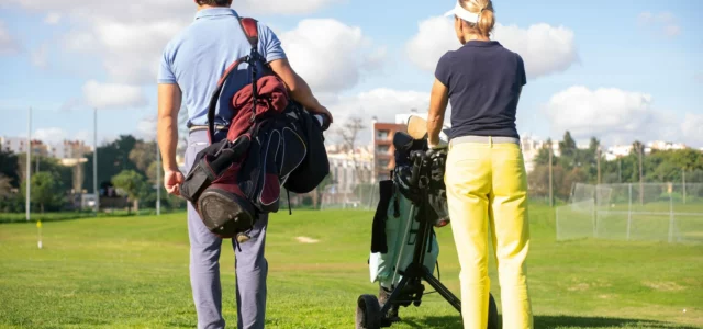 Golfeur, sac sur l'épaule, et golfeuse avec son chariot, de dos, face au parcours