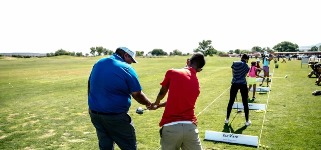 Golfers lined up on an open driving range