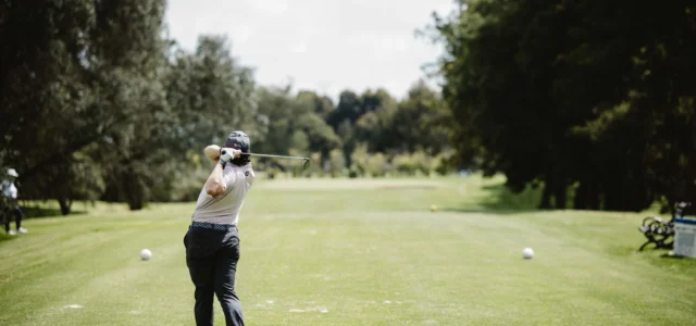 Golfeur en plein swing vu depuis le fairway