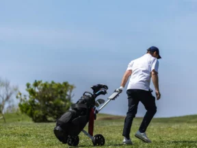 Golfeur poussant son chariot sur le parcours