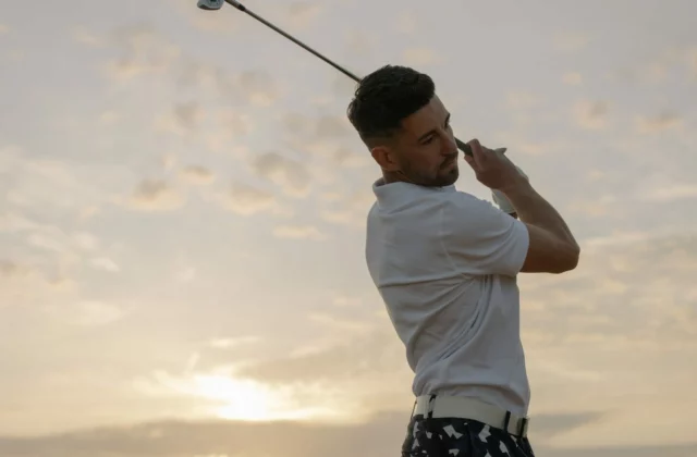 Golfer finishing a swing at sunset