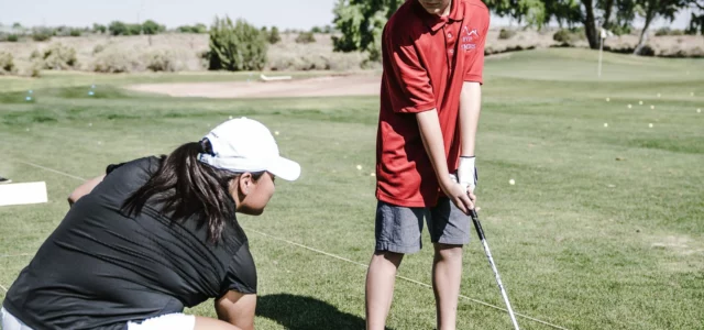 Group golf lesson, coach and beginners