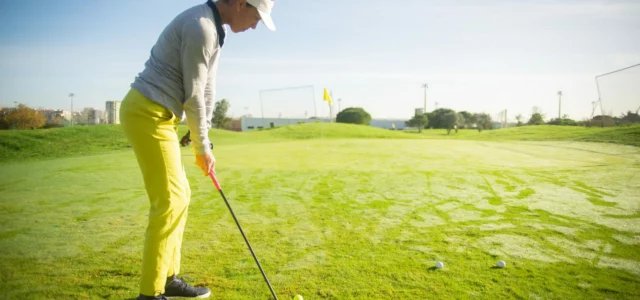 Woman golfer mid-swing on the range