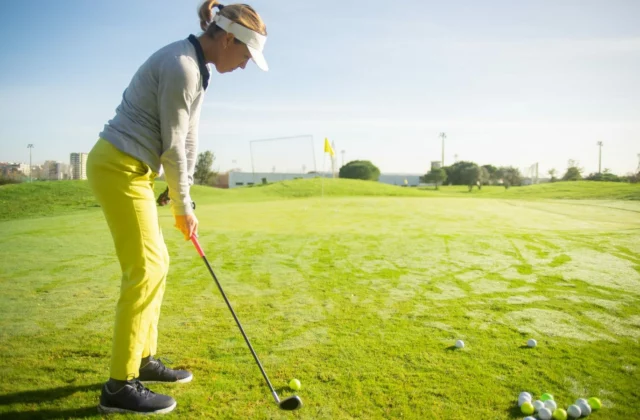 Woman golfer mid-swing on the range