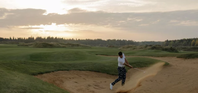 Golfer walking through the dunes of a links