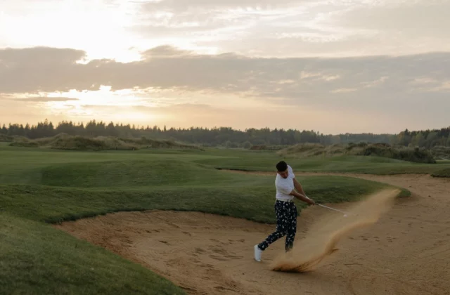 Golfer walking through the dunes of a links