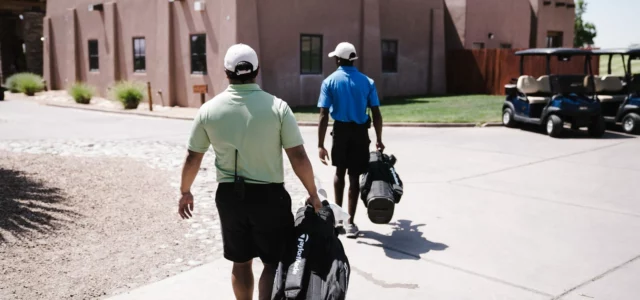 Two golfers walking to the car park with their bags