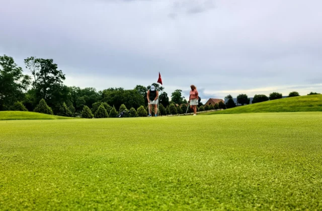 Green éloigné avec drapeau et joueurs de golf