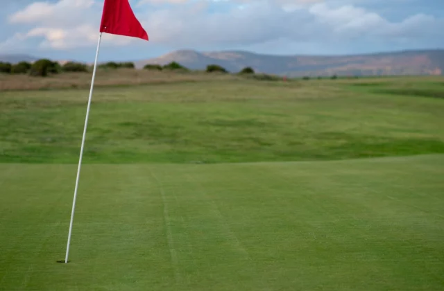 Drapeau rouge planté sur un green