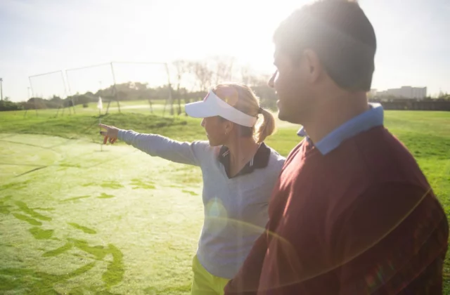 Deux golfeurs sur un practice, l'un montrant la cible