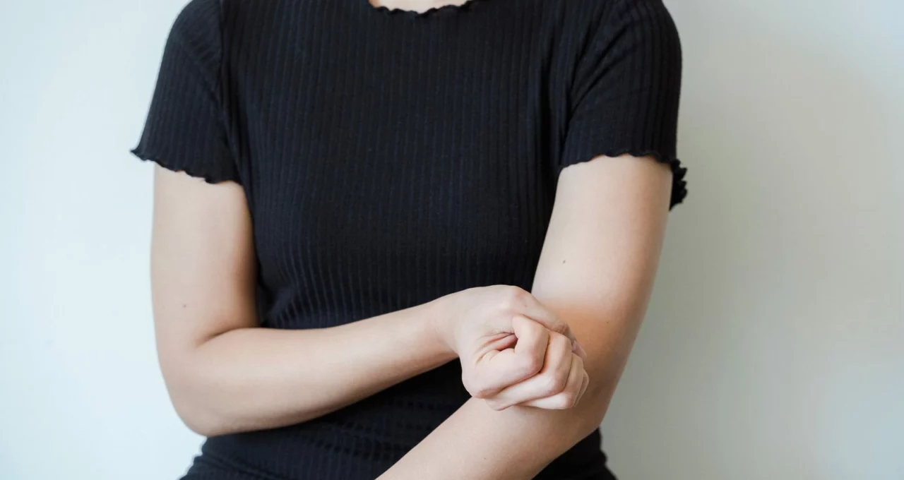 Une femme se tient l'avant-bras juste sous le coude
