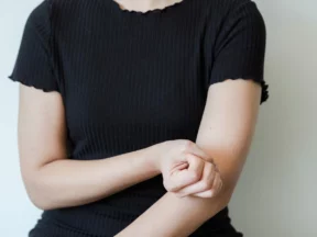 Une femme se tient l'avant-bras juste sous le coude